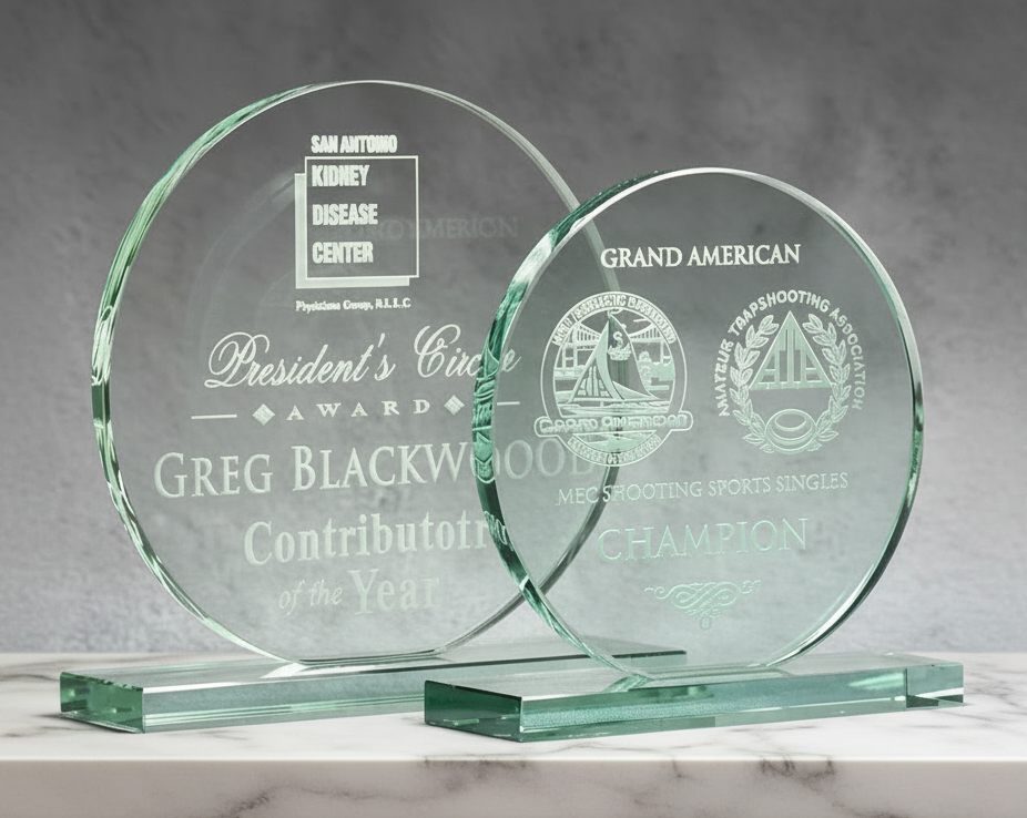 Two jade glass awards with engraved text on a gray background