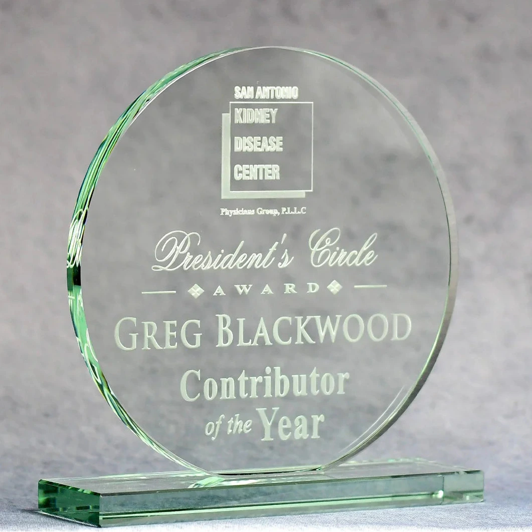 Glass award with engraved text on a gray background