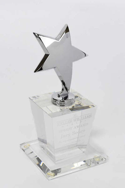 Polished metal star trophy mounted on a clear crystal base, modern, elegant, and award-ready design