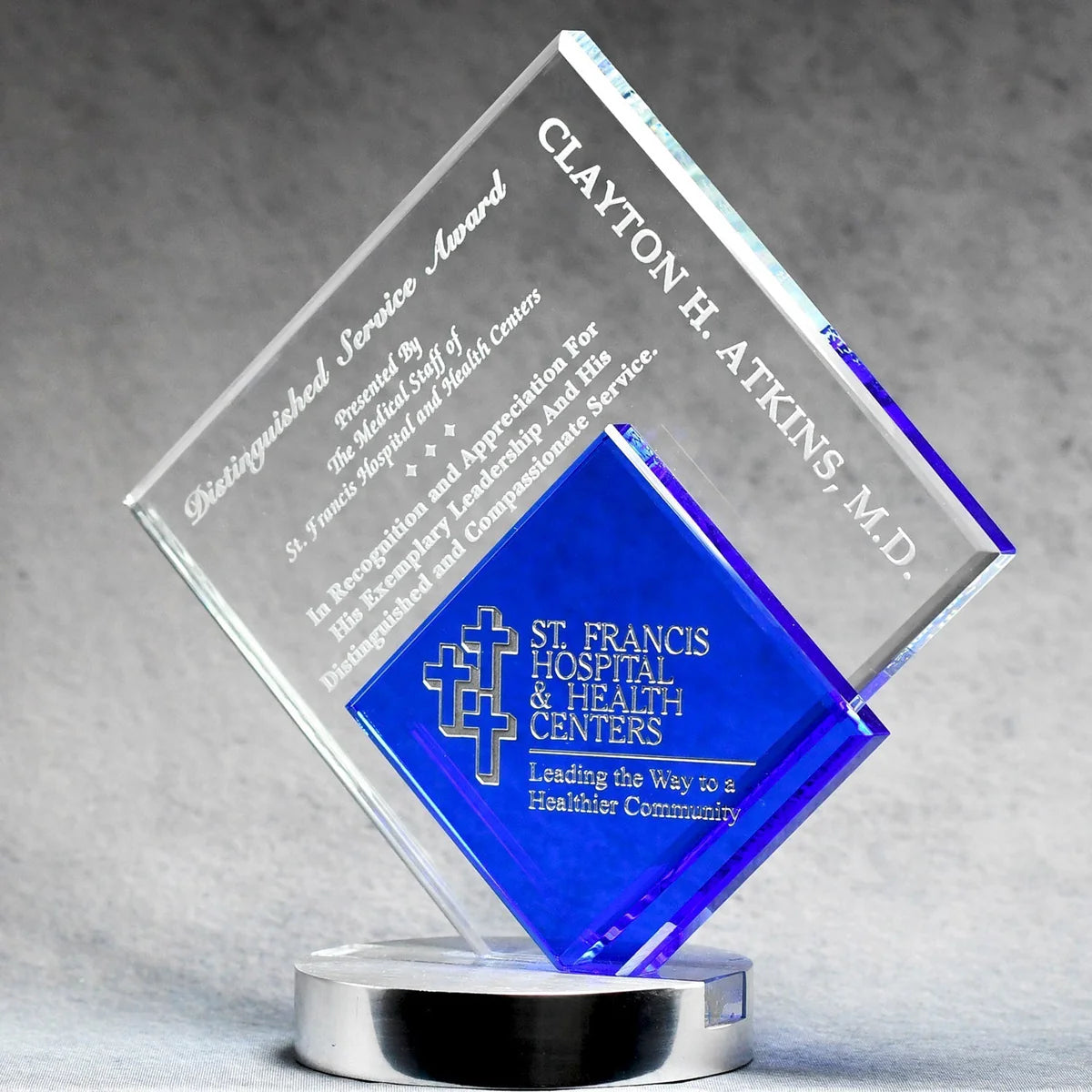 Clear and blue Glass award with sand etch engraved text and silver color fill on a gray background