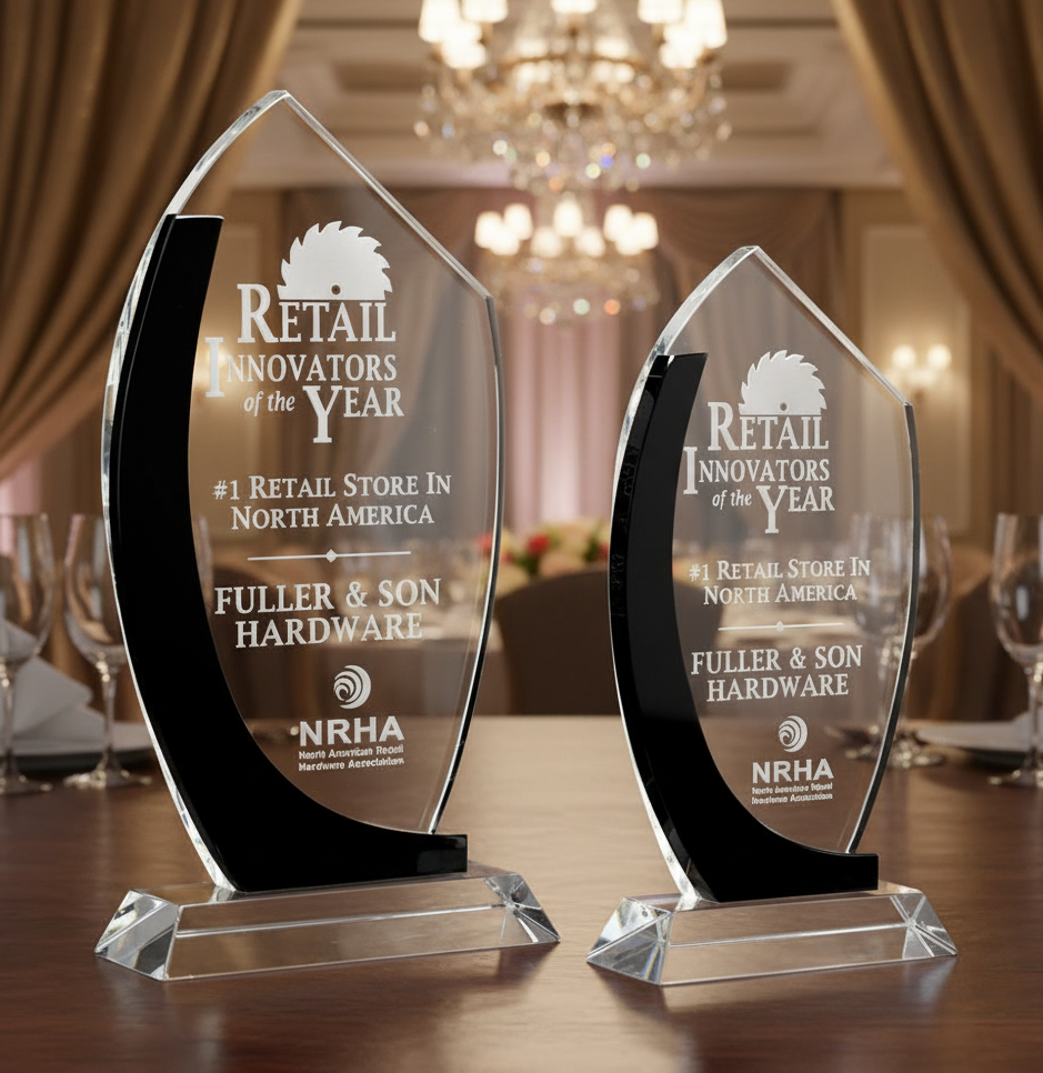 Two crystal awards with corporate logos and black accents on a table