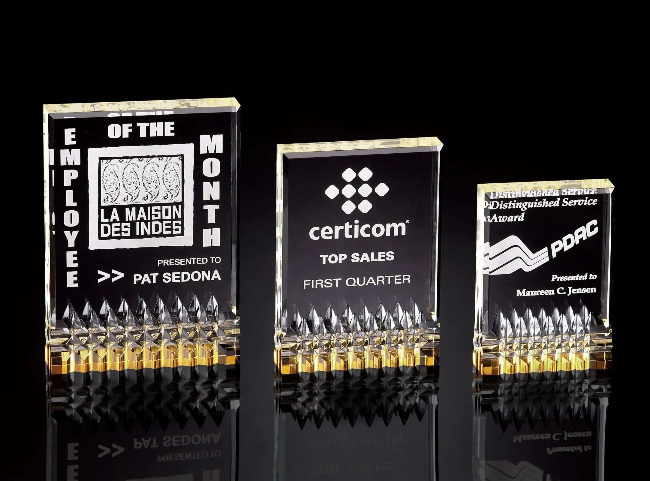 Three acrylic awards with engraved text and gold accent