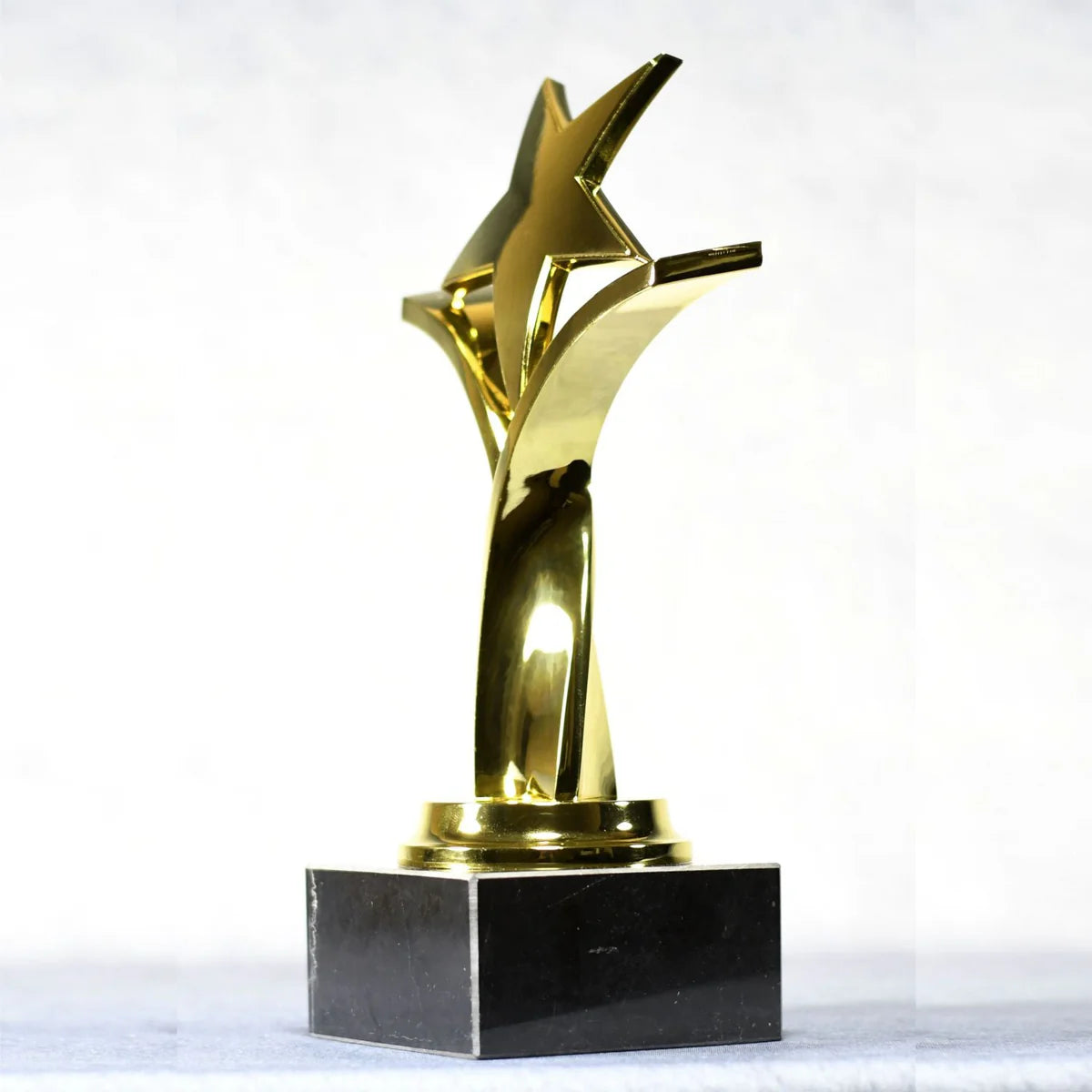 TWISTING STAR ON BLACK MARBLE BASE, GOLD, SILVER, BRONZE