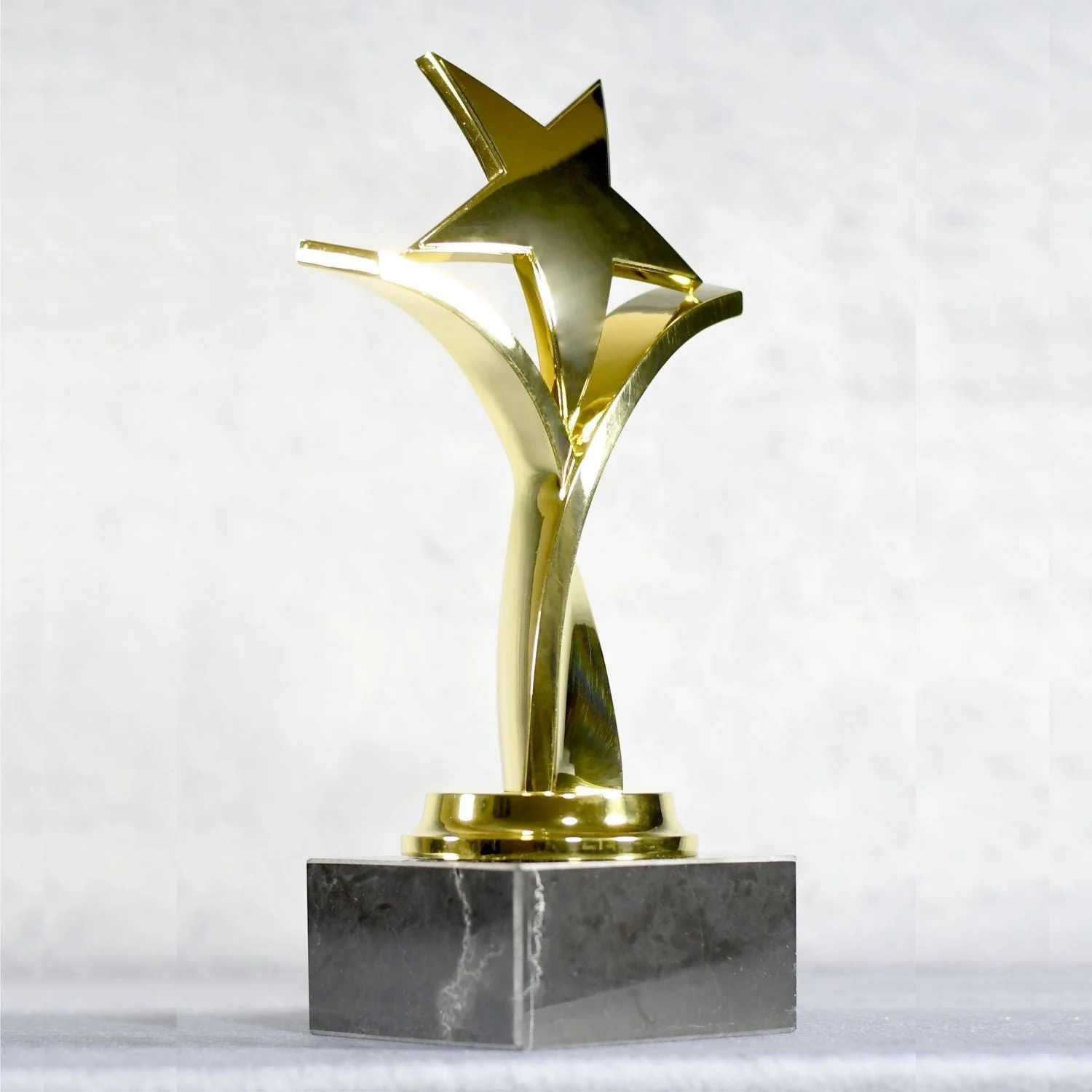 TWISTING STAR ON BLACK MARBLE BASE, GOLD, SILVER, BRONZE