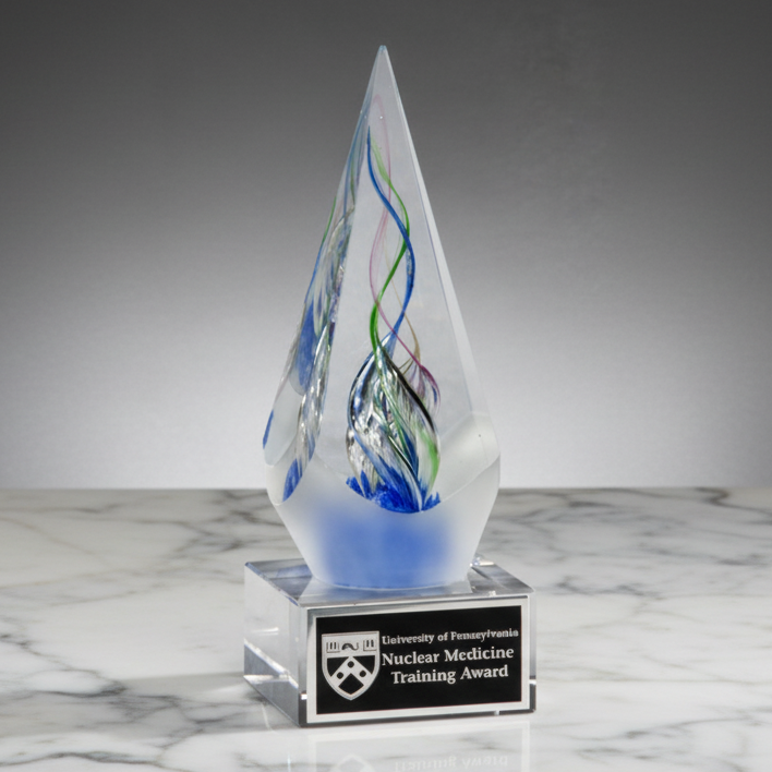 Decorative glass award with a base displaying 'University of Pennsylvania Nuclear Medicine Training Award' on a marble surface.