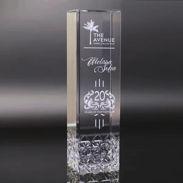 Crystal Tower award with sand etch engraved text and logo on a dark background