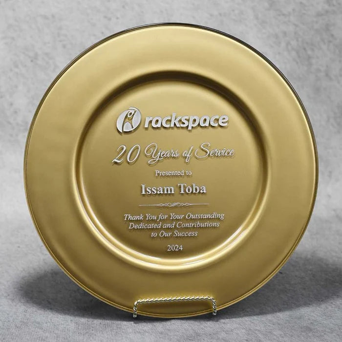 A gold commemorative glass plate with engraved text, presented on a gray background.