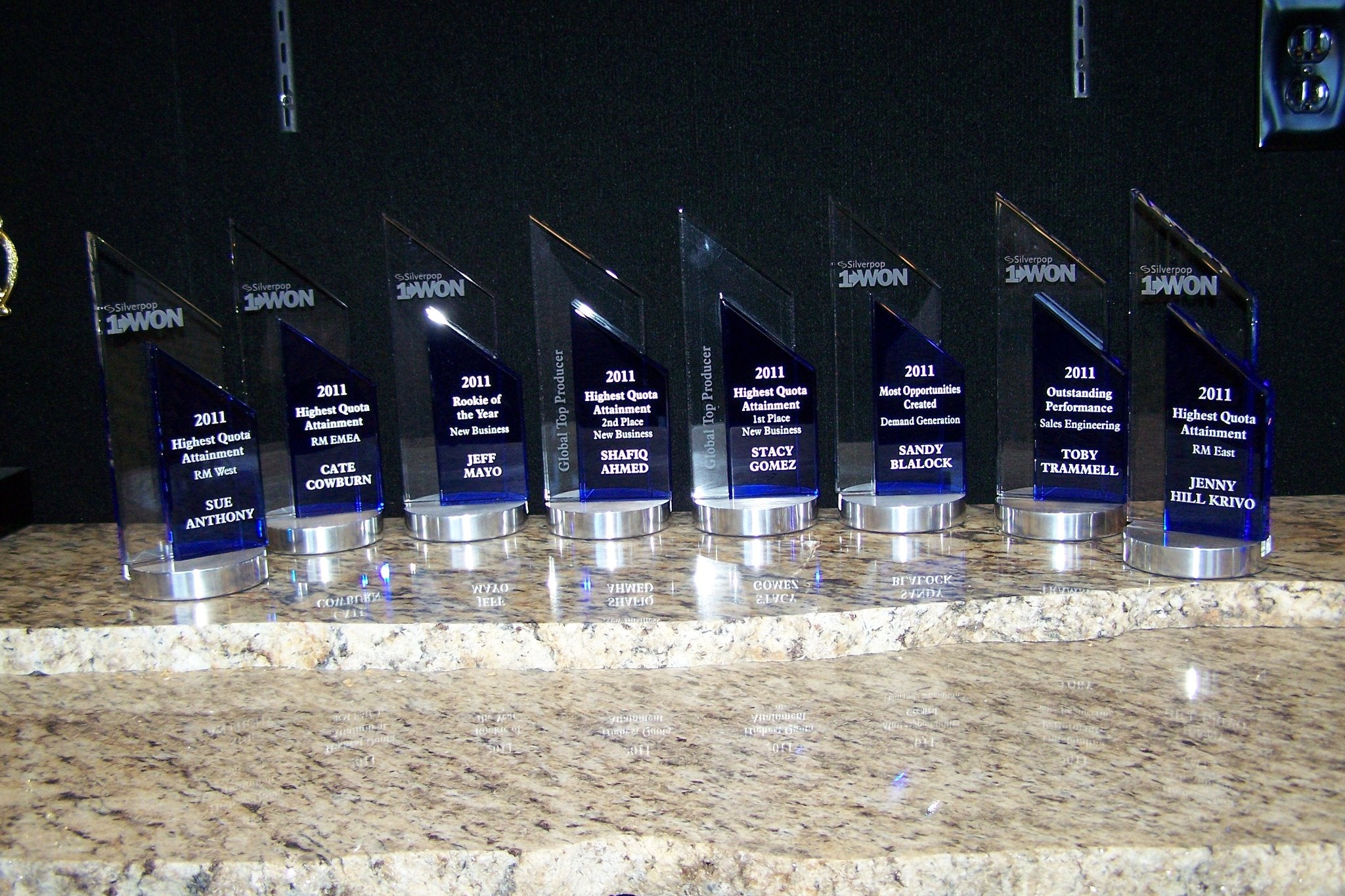 STUNING BLUE AND CLEAR CRYSTAL TOWER AWARD TROPHY ON A BRUSHED ROUND ALUMINUM BASE.