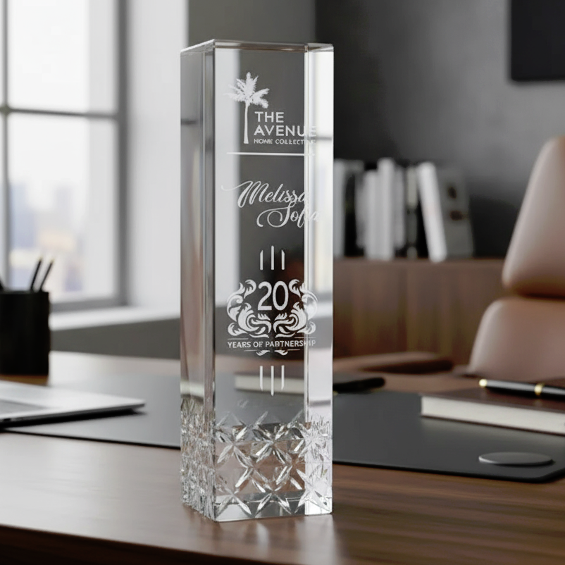 Crystal award on a desk with engraved text in an office setting