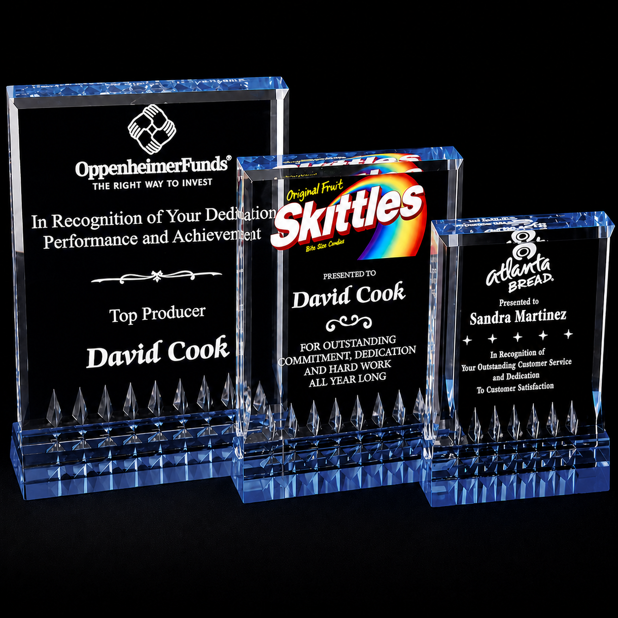 Three sizes of acrylic awards with engraved text and corporate logos.