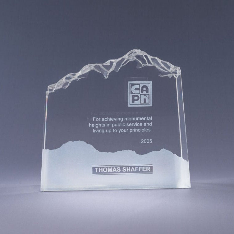 Glass award with mountain design and sand etch engraved text and logo on a gray background