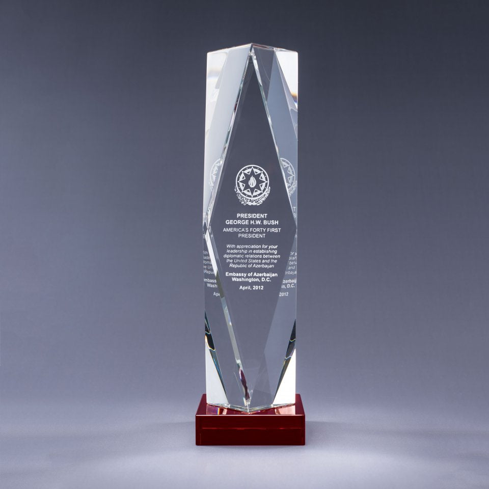 Tall, clear crystal award on a red crystal base with sand etch engraving and logo