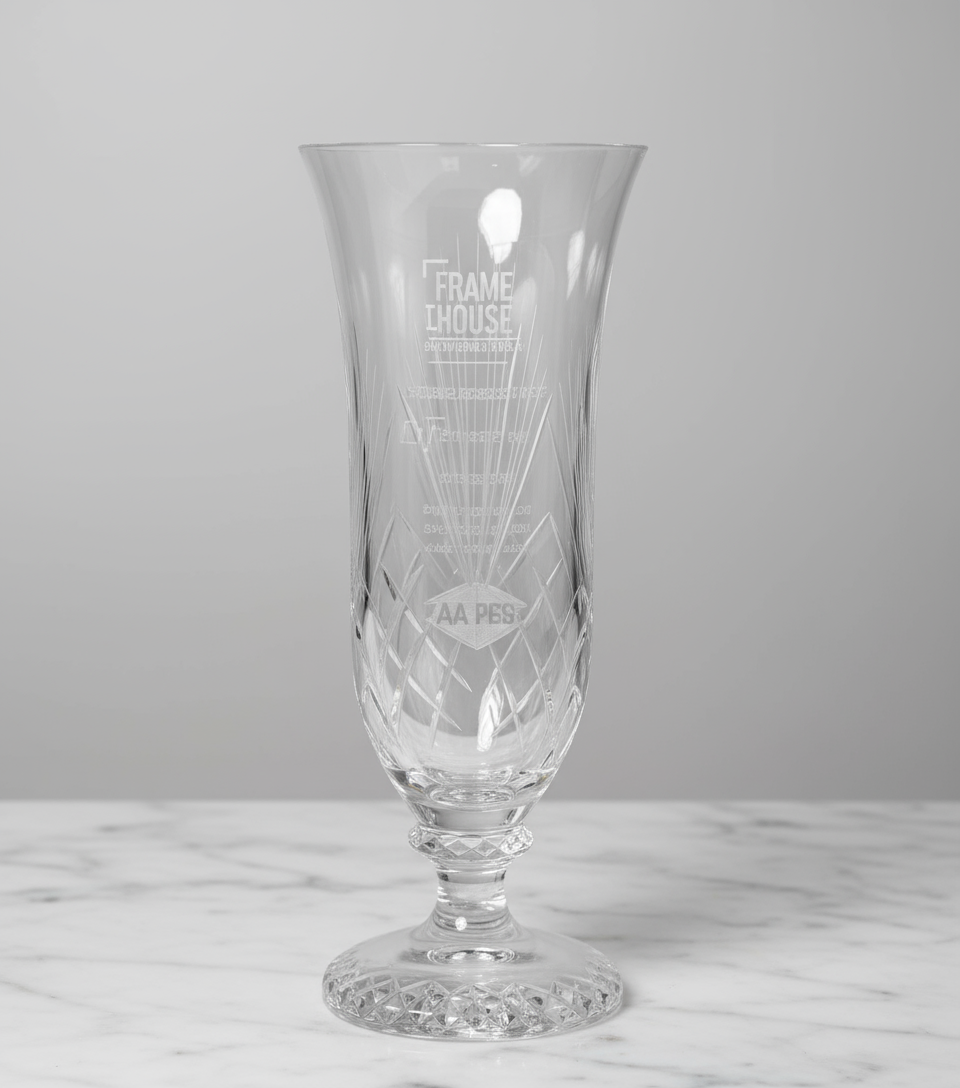 Clear glass vase with engraved design on a marble surface