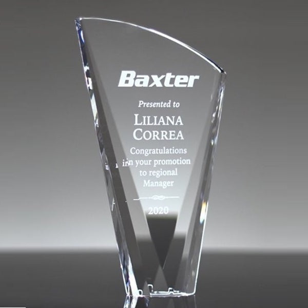 Clear glass award with engraved text on a gray background