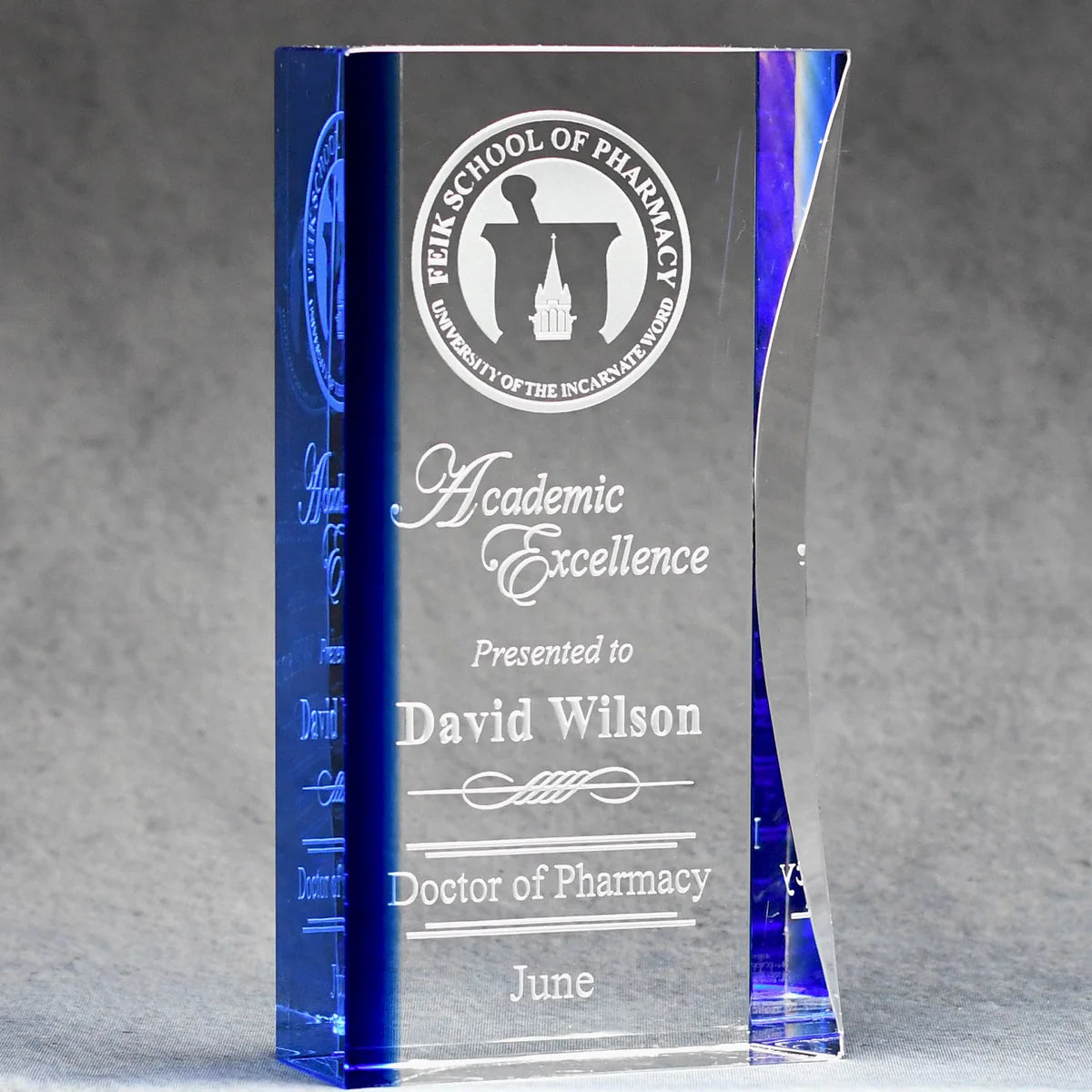 Elegant optic crystal award with blue tint along left side, logo and text sand etched and color filled white
