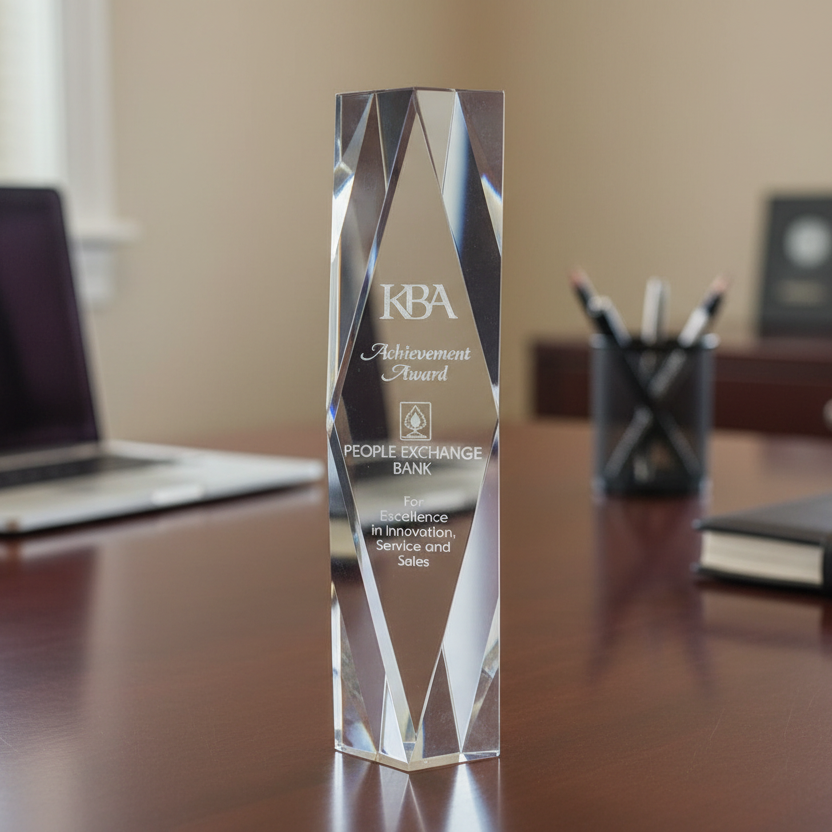 Crystal KPA award on a desk with office items in the background