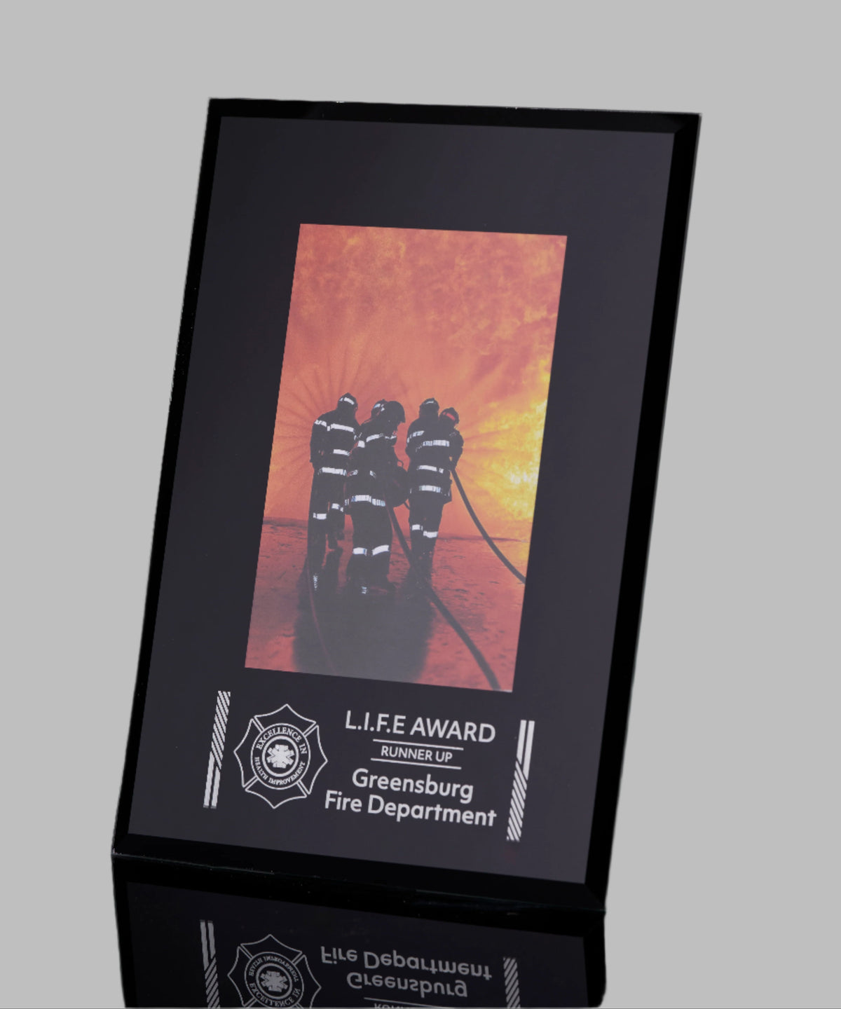 Framed photo of firefighters with 'L.I.F.E Award' text on a gray background