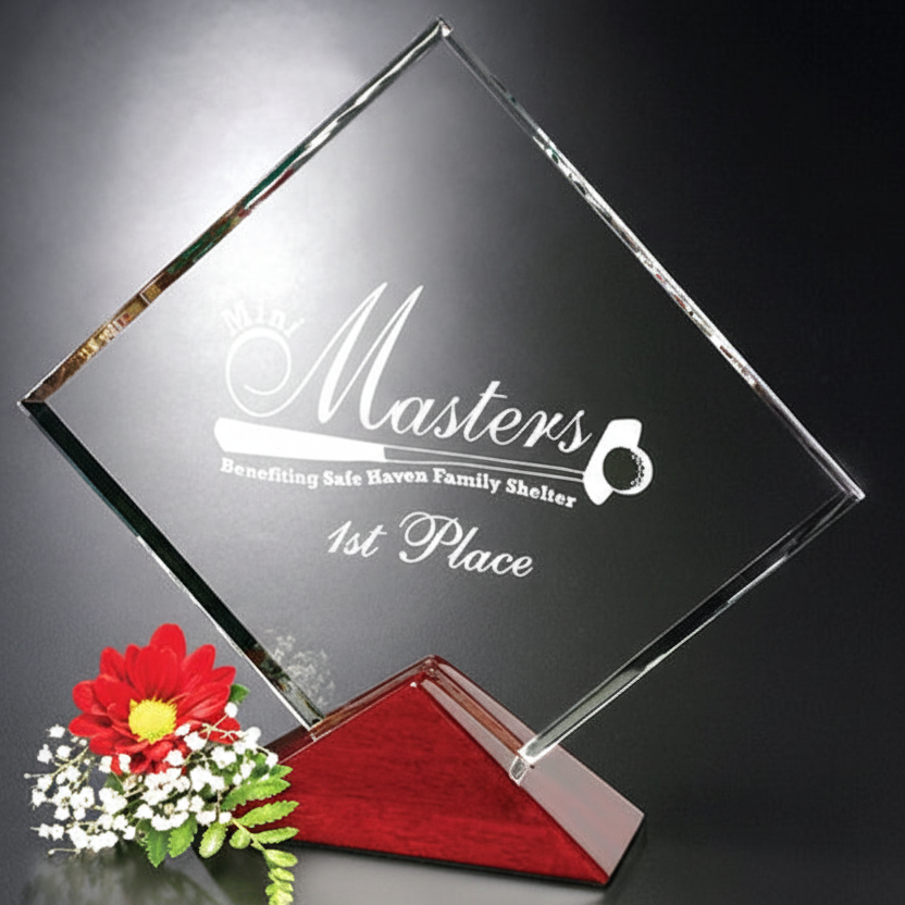 Clear glass award with engraved text on a dark background