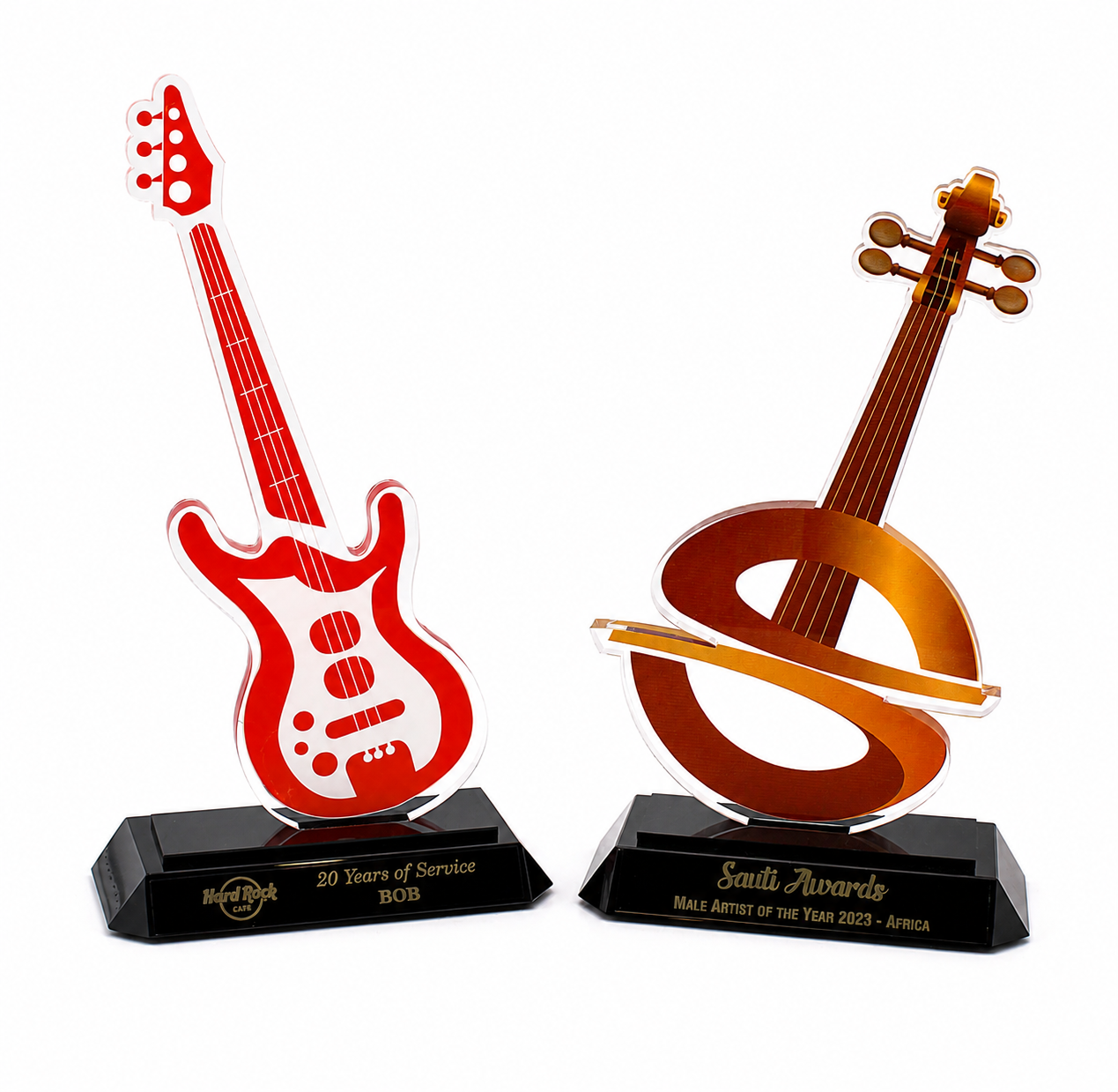 Two custom acrylic awards, one in the shape of a red guitar and the other resembling a brown violin, both mounted on black glass bases.
