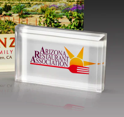 Clear acrylic block with logo on a gray surface