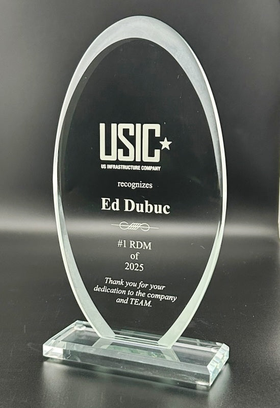 Glass award with engraved text on a black background