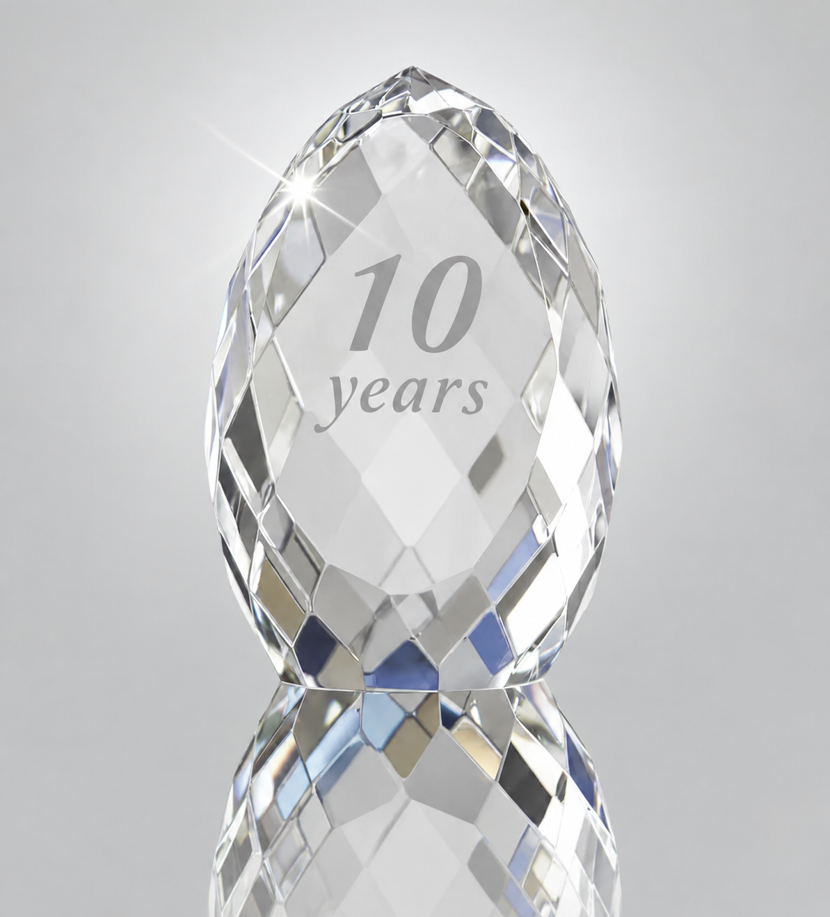 A faceted crystal-style egg-shaped keepsake or award piece engraved with the text '10 years'.