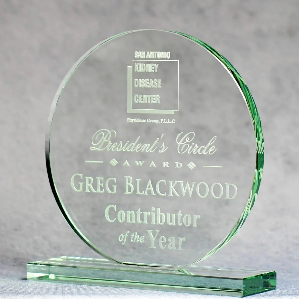 Glass award with engraved text on a gray background