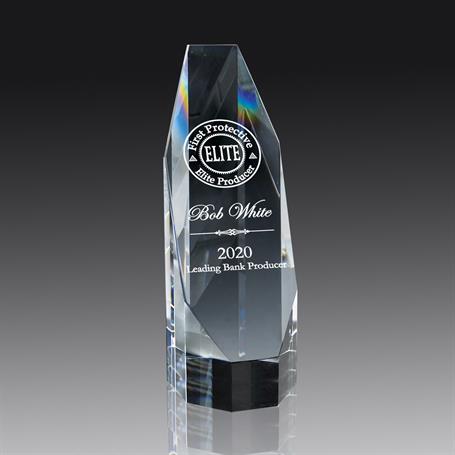 An optic crystal silhouette tower award with a personalized engraving, displayed on a reflective surface.