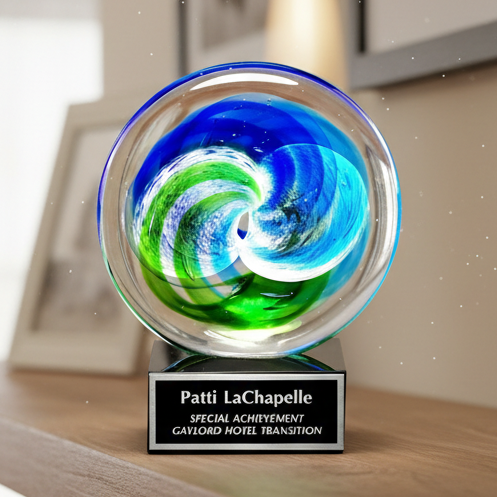Decorative glass sphere with swirling colors on a wooden surface