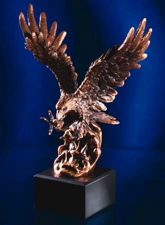 Bronze eagle sculpture on a dark blue background