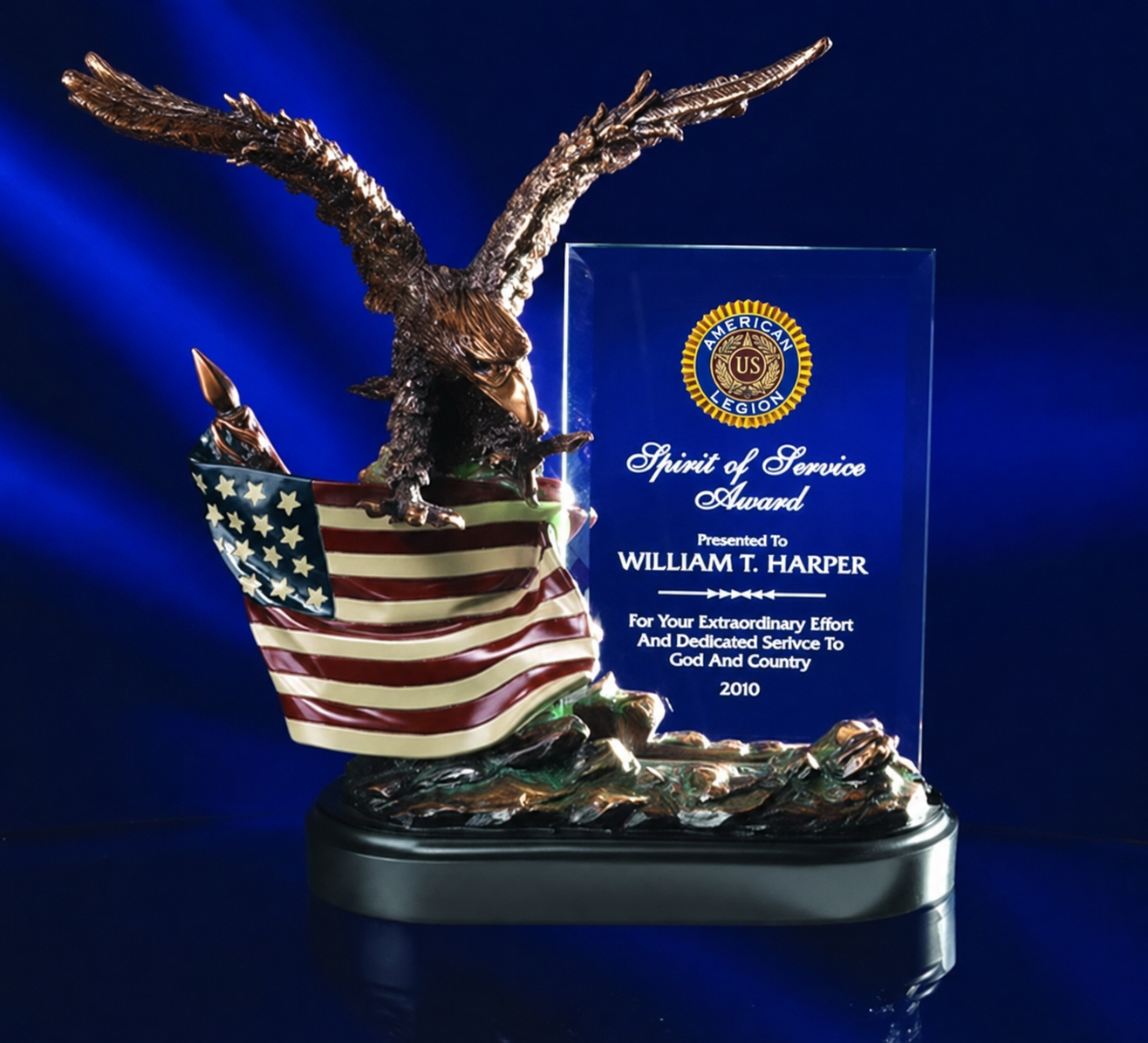 A decorative award trophy featuring a bronze eagle perched on a U.S. flag