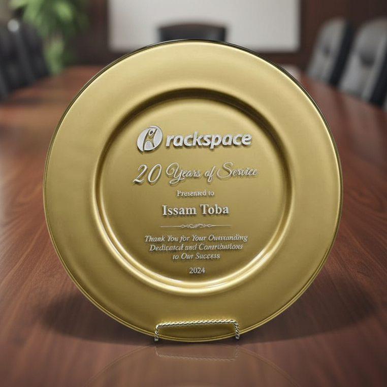 Gold plaque with 'Rackspace' logo and text on a wooden surface