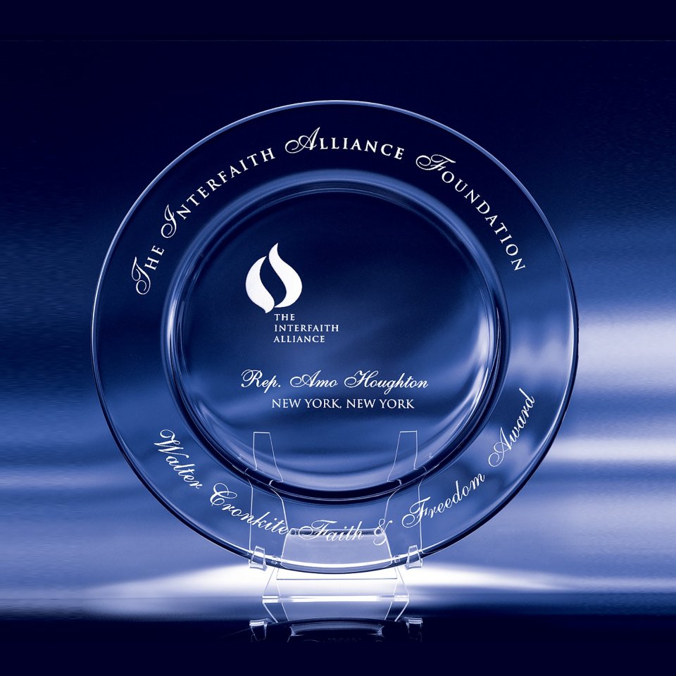 Clear glass award with engraved text and logo on a dark blue background