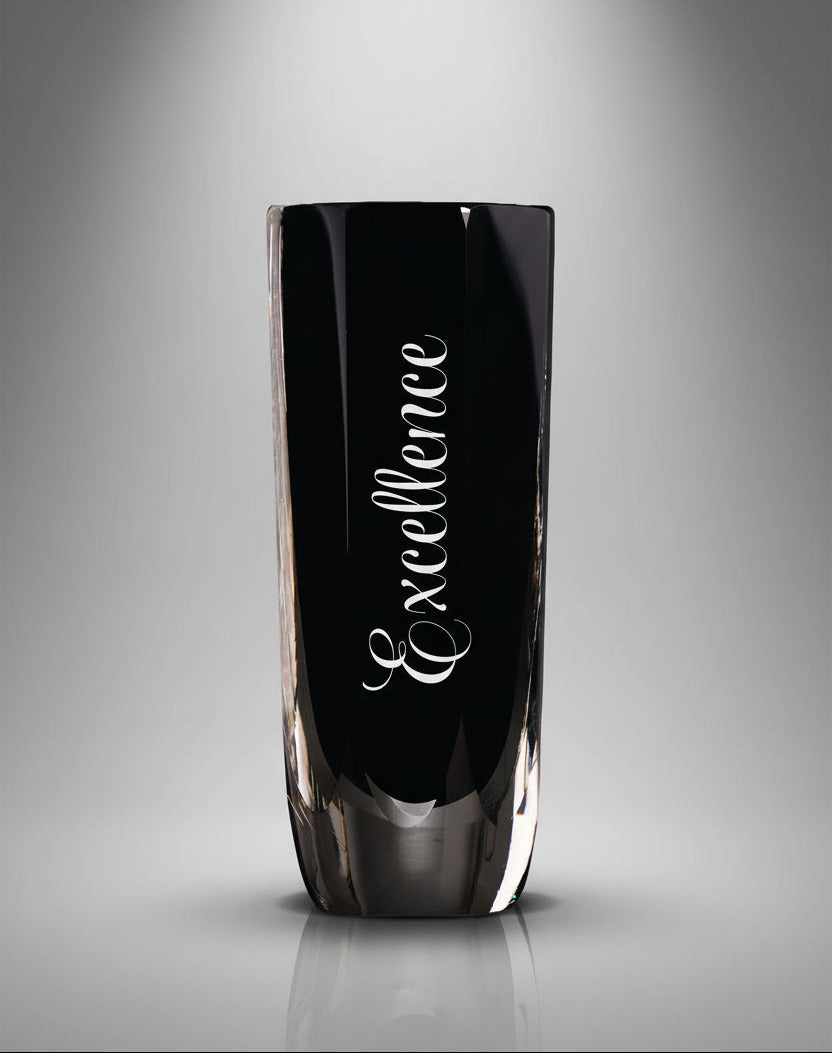 Black glass vase with 'Excellence' engraving on a gray background