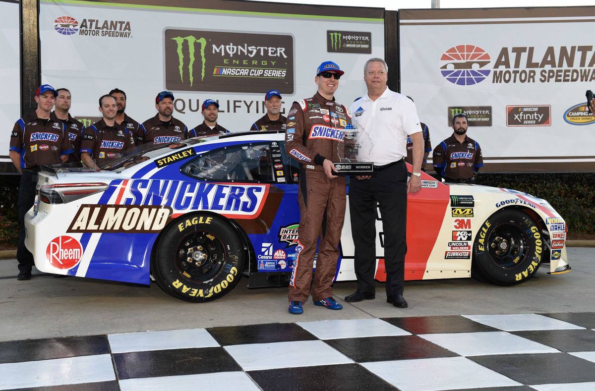 Group of people posing with a NASCAR car at Atlanta Motor Speedway