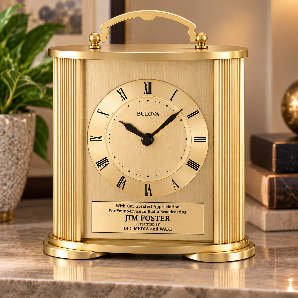 Bulova Arthur gold-finish mantel clock with ribbed sides and custom engraved plate on a marble shelf.