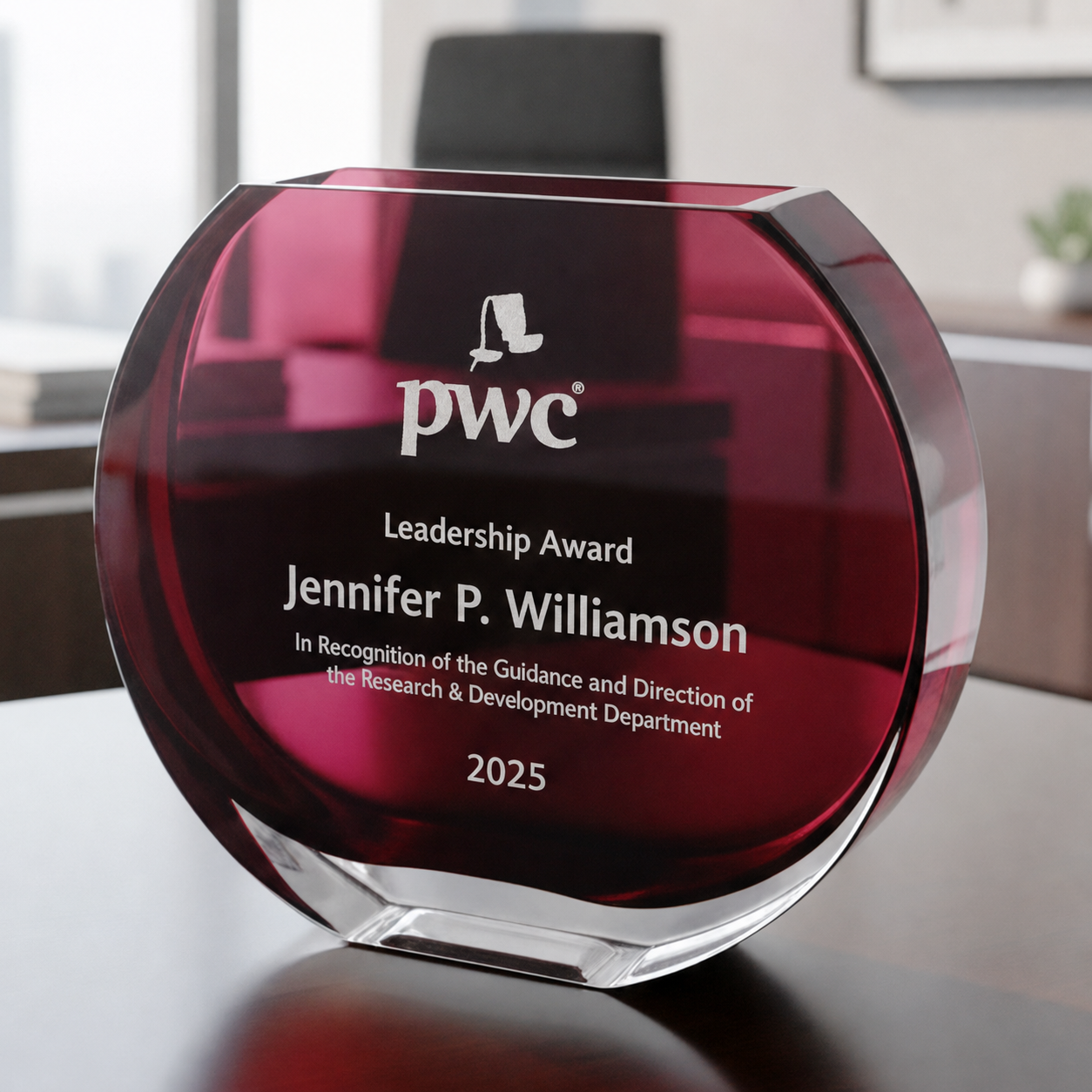 PricewaterhouseCoopers (PwC) Leadership Award for Jennifer P. Williamson on a reflective surface with a blurred office background.