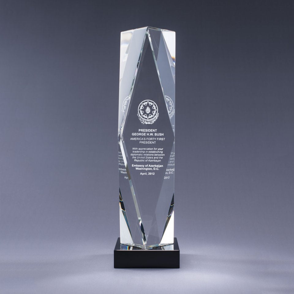 Crystal award with engraved text on a black crystal base. Sand etch engraved logo and text
