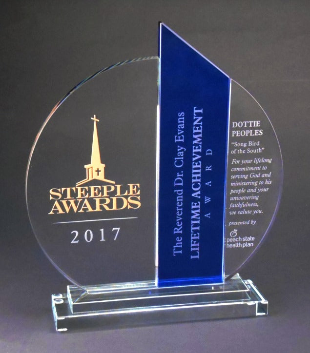 A blue and clear optic crystal award featuring a vibrant cobalt blue tower on a two-tier crystal base, with deep etch engraving of a church steeple and text.