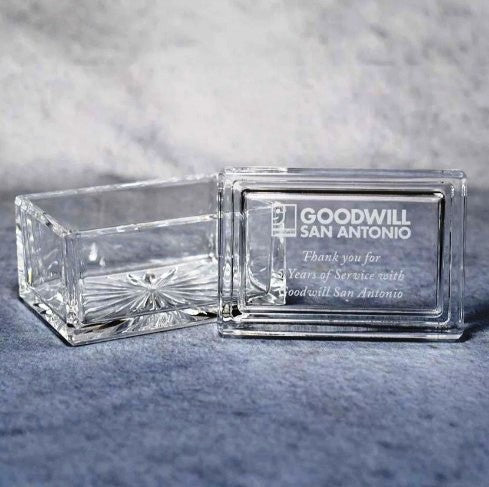 Clear glass block with engraved text on a gray surface