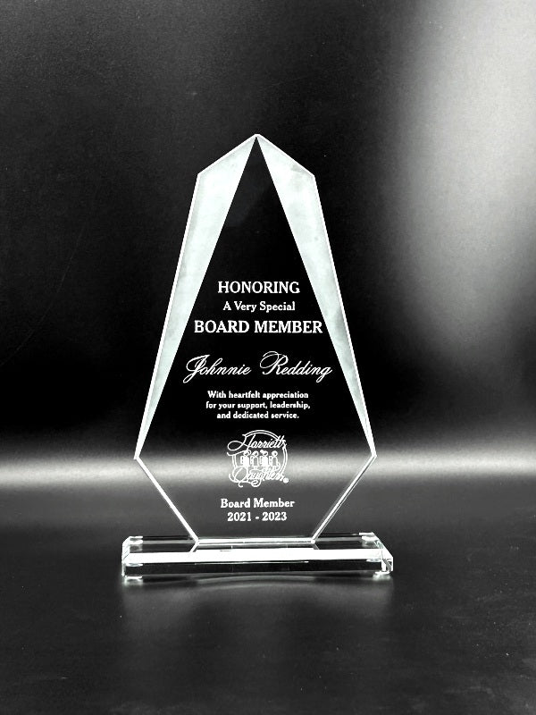 Crystal award honoring a board member with engraved text on a black background