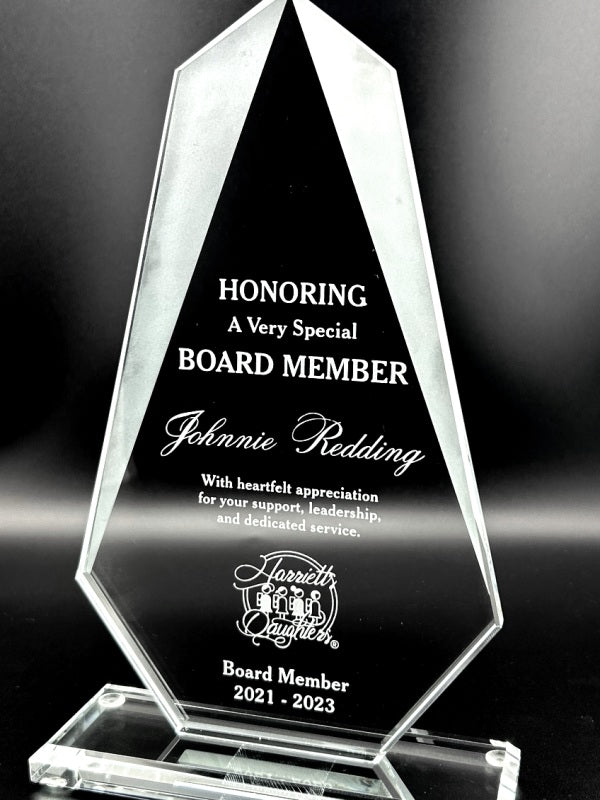 Crystal award honoring a board member with engraved text on a dark background