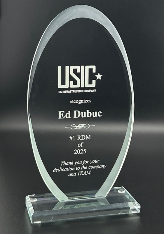 Glass award with engraved text recognizing Ed Dubuc as #1 RDM of 2025 by USIC.