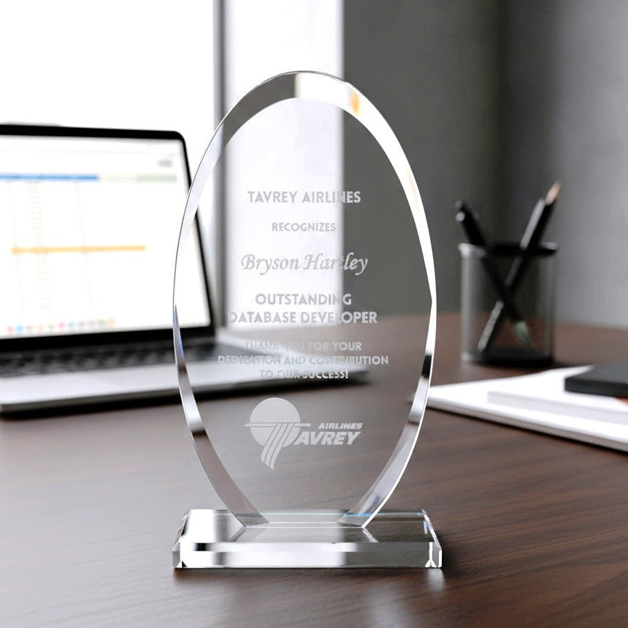 Glass award on a desk with a laptop in the background