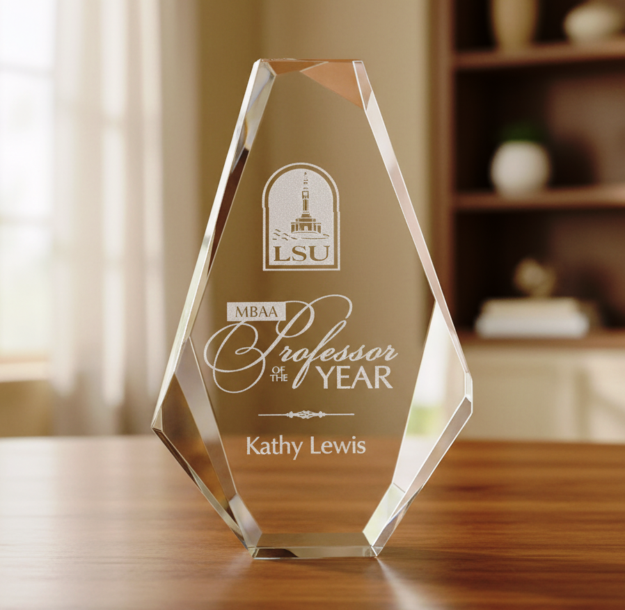 Glass award with engraved text on a wooden surface