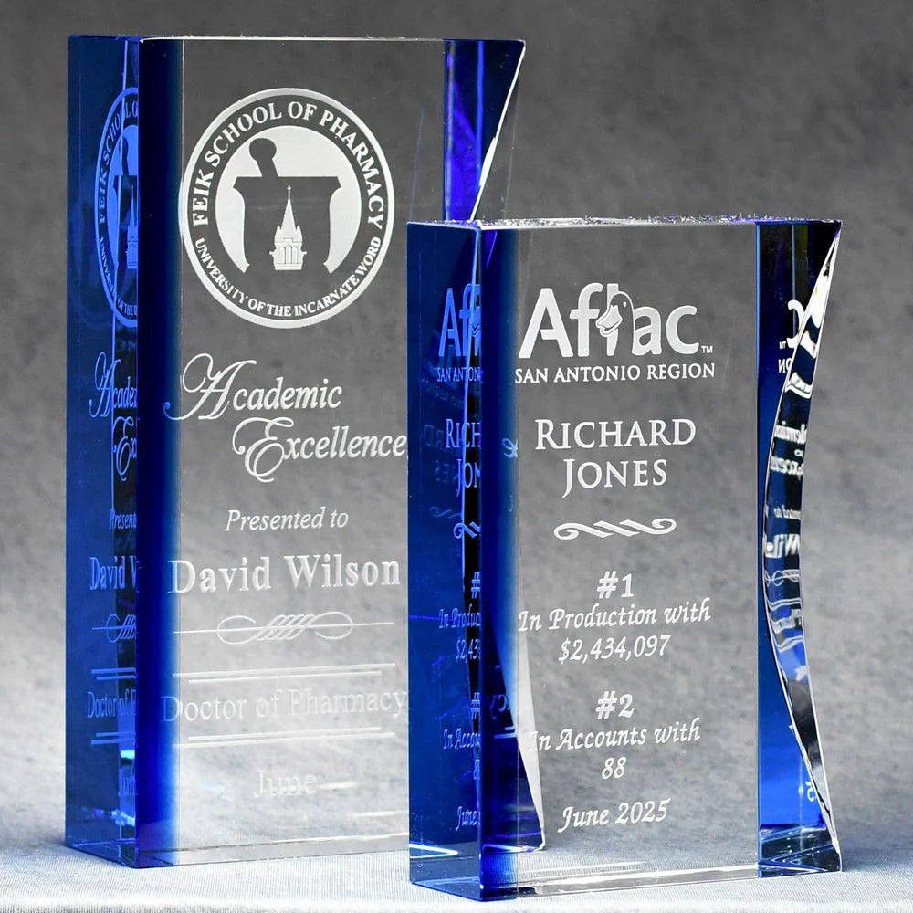 Two optic crystal awards with engraved text, with a blue tint on the left side and clear on the right, Both have white color fill sand etch engraving.