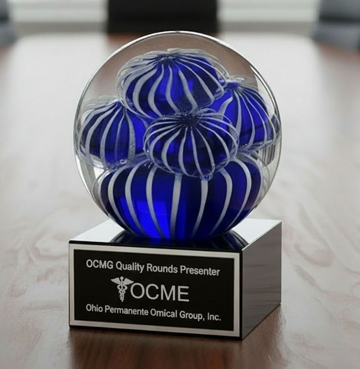 Decorative glass sphere award with blue and white patterns on a black base in a conference room.